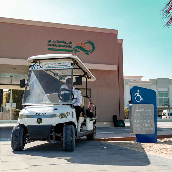 Electric buggy parked outside a Dubai Beaches building next to an accessibility sign